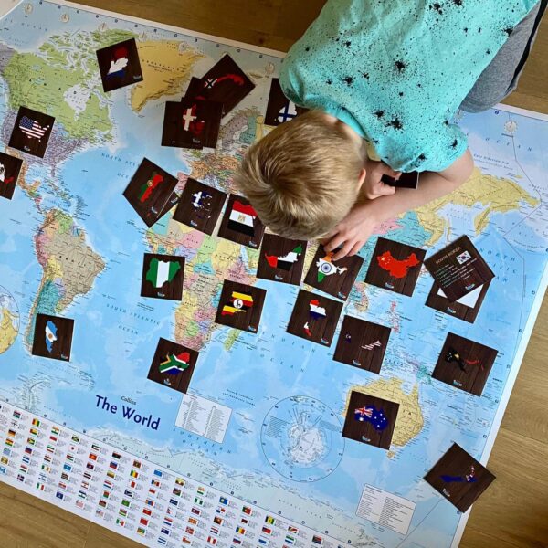 Young boy with a large world map learning Geography with Teddo Play Learning Resources